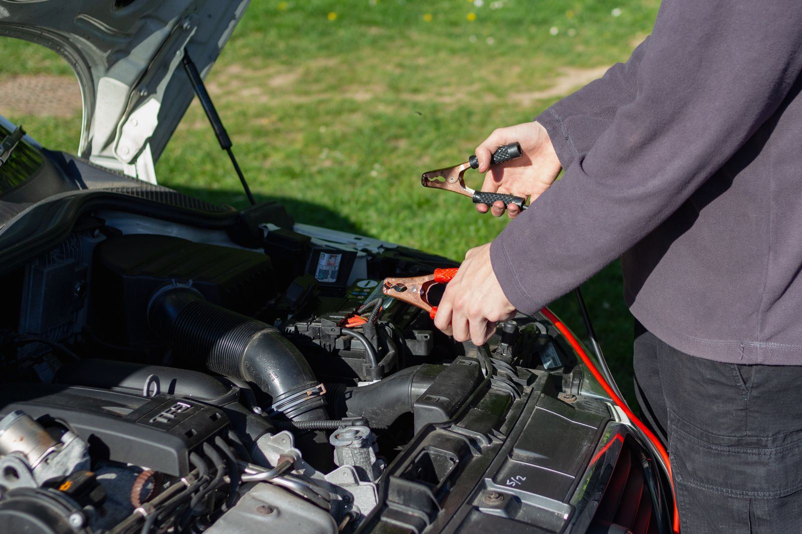 Jumper cables connected to a car battery